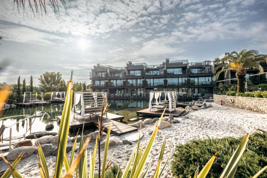 een resort met stoelen en water bij Quellenhof Luxury Resort Lazise in Lazise