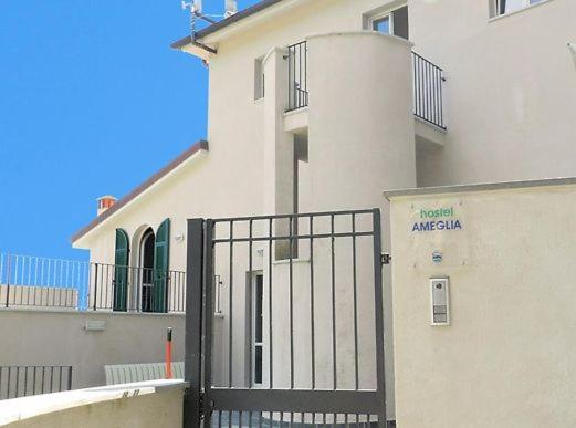 a building with a gate in front of a building at Il Pescemagra HostelAmeglia in Ameglia