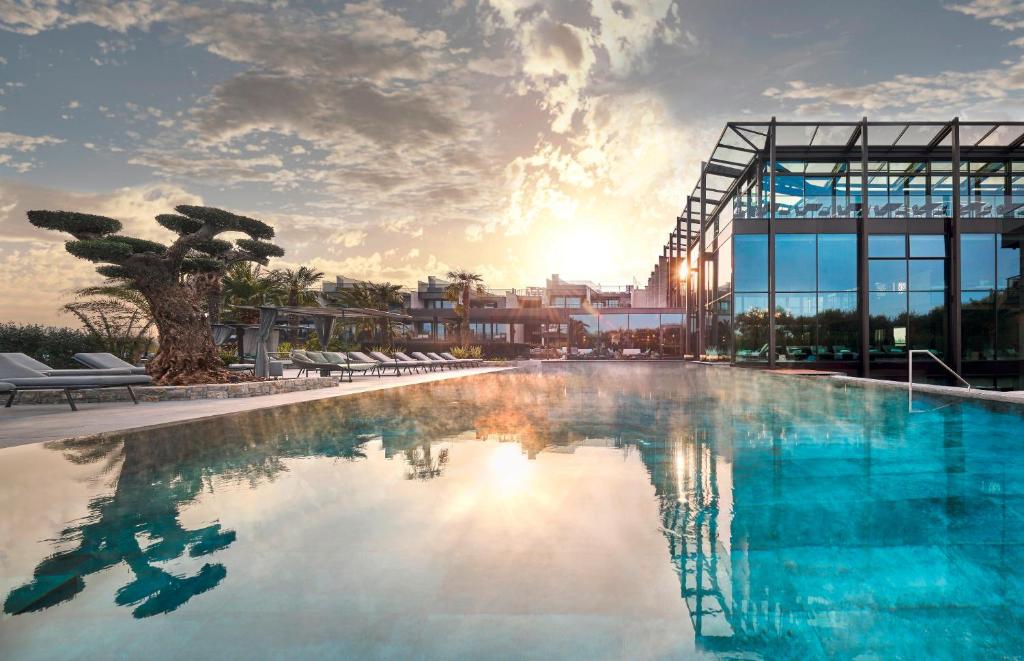 una grande piscina di fronte a un edificio di Quellenhof Luxury Resort Lazise a Lazise