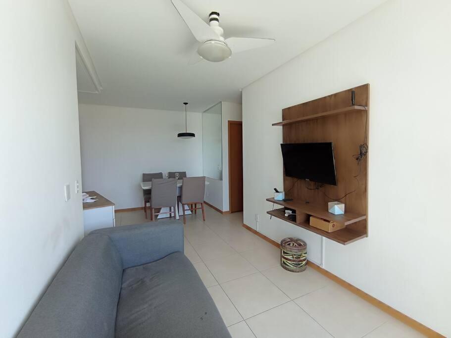 ein Wohnzimmer mit einem Sofa und einem Flachbild-TV in der Unterkunft AP Vista Panorâmica da Praia in Guarapari