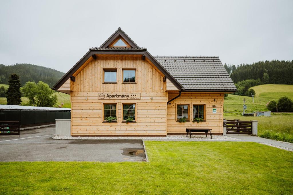 a wooden building with a bench in front of it at Apartmány Velké Karlovice in Vsetín