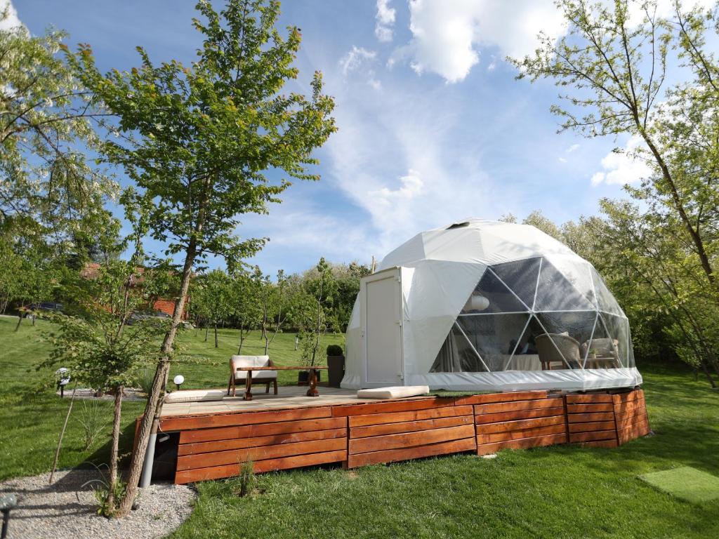 a dome house with a wooden deck in a garden at Cherry Glamping Vranic in Vranić