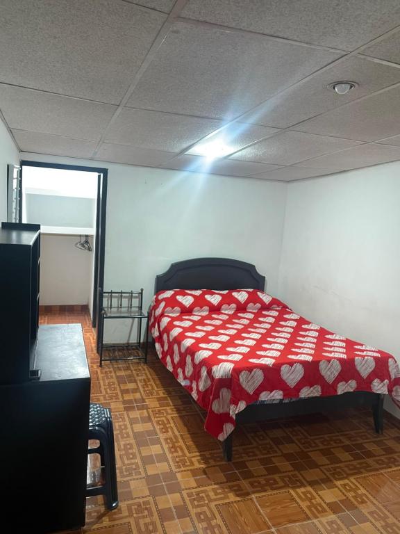 1 dormitorio con 1 cama con manta roja en Habitación con baño privado para 1 o 2 personas, en Manizales