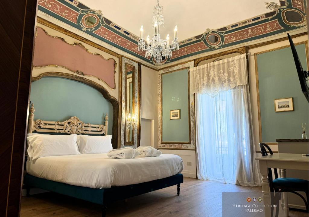 een slaapkamer met een groot bed en een kroonluchter bij Heritage Collection Palermo B&B in Palermo