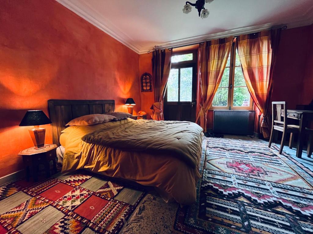 a bedroom with a bed and a table and a window at Le buisson de la Gariole in Aubigny-sur-Nère