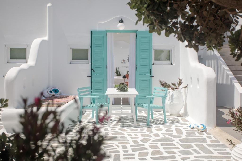 una camera con porta blu e tavolo e sedie di Naxos Cave Suites a Stelida