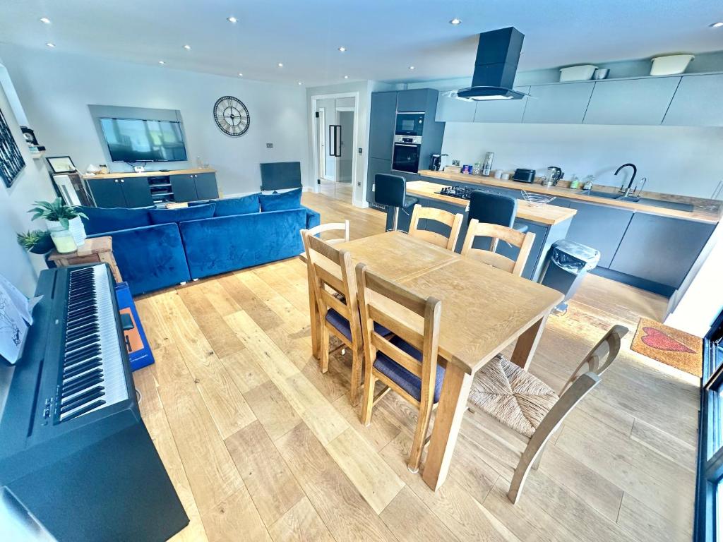 eine Küche und ein Wohnzimmer mit einem Tisch und Stühlen in der Unterkunft Spacious Modern Bungalow with Garden, Hot Tub, Gas BBQ and SKY Sports! in Bournemouth
