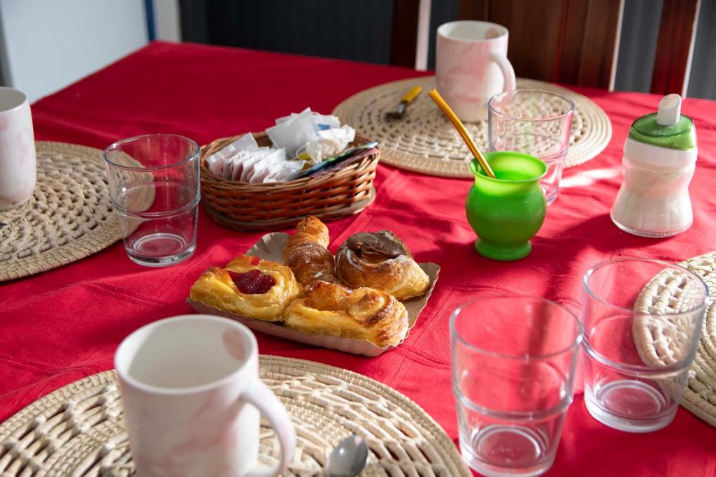 a table with a red table cloth with pastries on it at Departamento del Bosque equipado para 4 patio parrilla cochera cubierta in Maipú