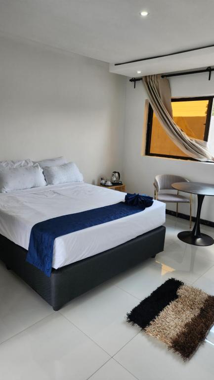 Koluti Apartments في ندولا: غرفة نوم بسرير وطاولة ومكتب