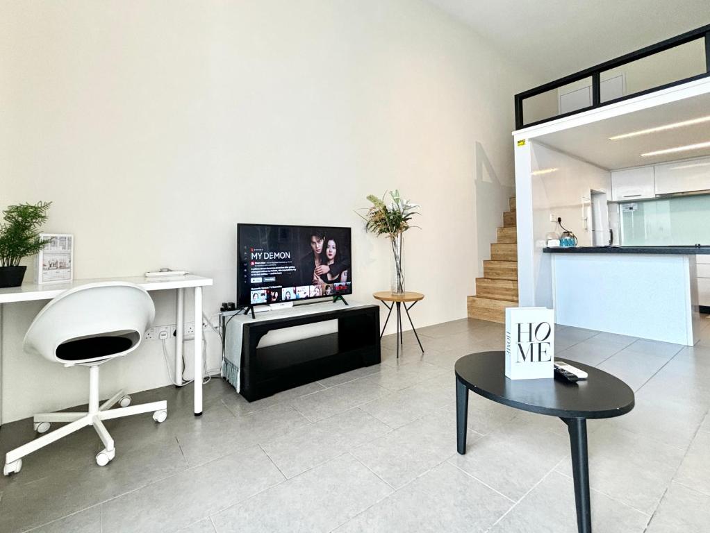 a living room with a tv and a chair and a table at Lynhomes The Establishment Bangsar KL City Sentral Modern Studio Loft in Kuala Lumpur