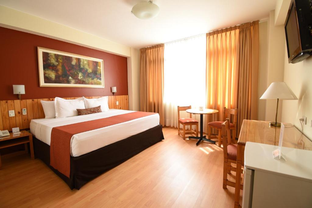 Habitación de hotel con cama y TV en Qorianka Hotel en Lima