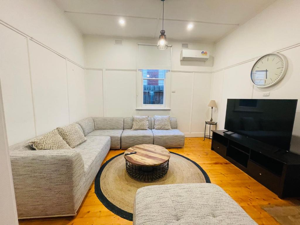 a living room with a couch and a tv at D114 Victorian Central Stay in Melbourne