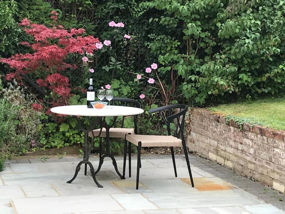 einen Tisch mit 2 Stühlen und eine Flasche Wein in der Unterkunft House with garden in Hertford in Hertford