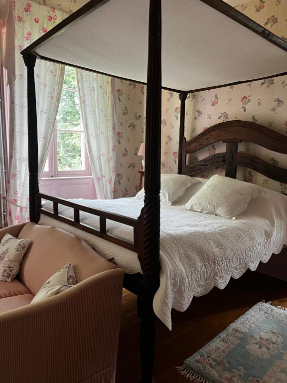 Poisson的住宿－Chateau De Martigny，一间卧室配有一张天蓬床和一把椅子