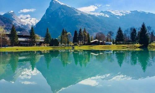 une masse d'eau avec une montagne en arrière-plan dans l'établissement Charmant mobilhome à 2 pas remontés ski Samoëns, à Samoëns