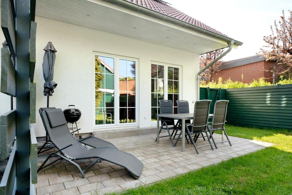 a patio with a table and chairs in a yard at Feriendoppelhaus Sommer in Stakendorf