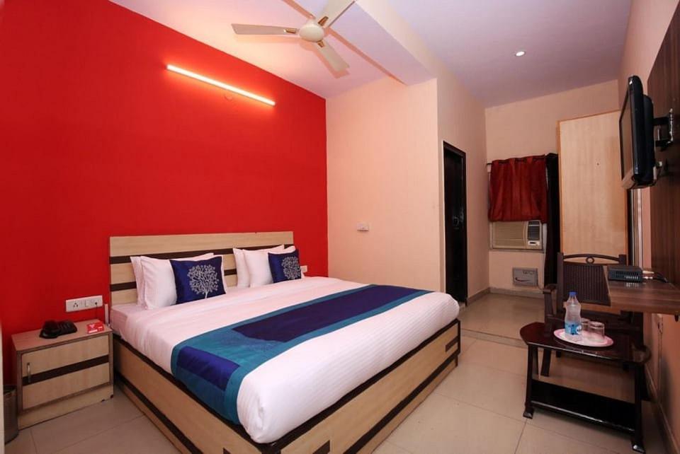 a bedroom with a large bed with a red wall at Hotel Parkash Inn in Jalandhar