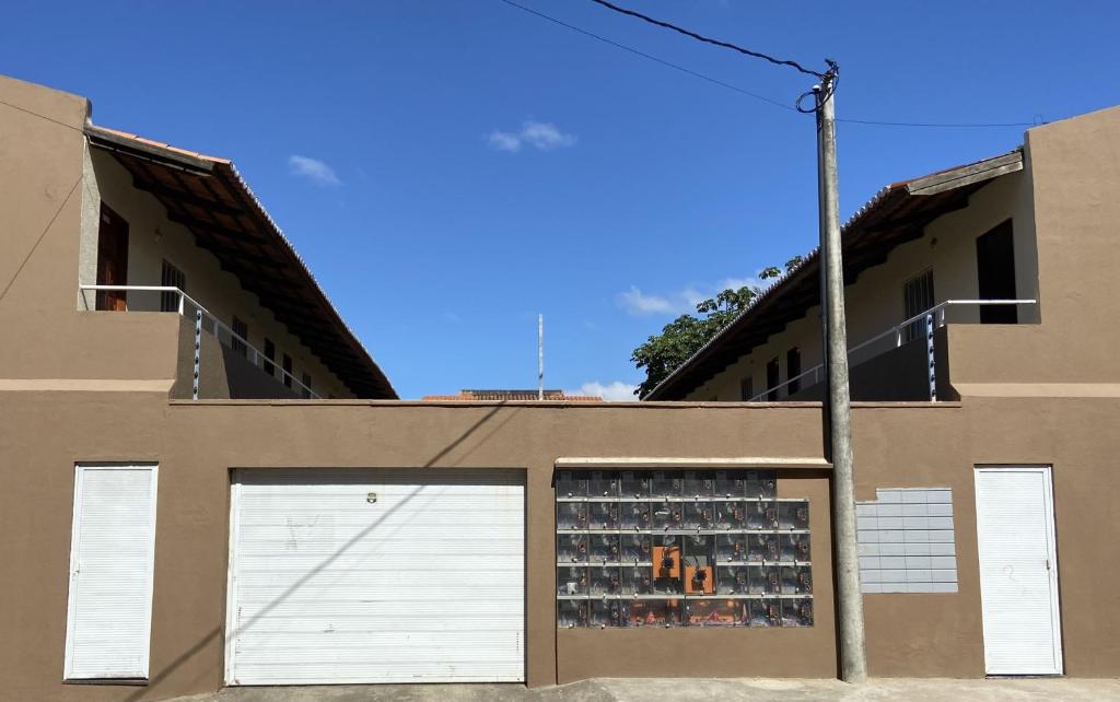 un edificio con dos puertas blancas de garaje con mucha gente en Apartamento Essecial Simplu, en Maracanaú