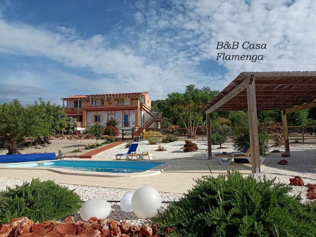 ein Resort mit einem Pool und einem Gebäude in der Unterkunft B&B Casa Flamenga in Alte