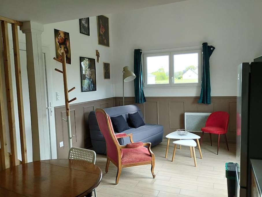 ein Wohnzimmer mit einem blauen Sofa und einem Tisch in der Unterkunft La Rose du Bel Homme in Rocroi
