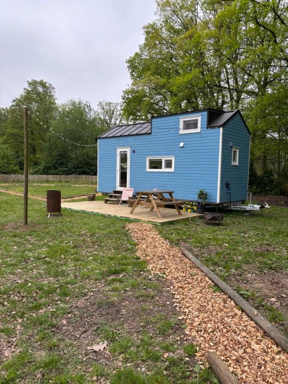 ein blaues winziges Haus mit einem Picknicktisch in der Unterkunft Prullenbos Tiny Nutz Nest in Wetteren
