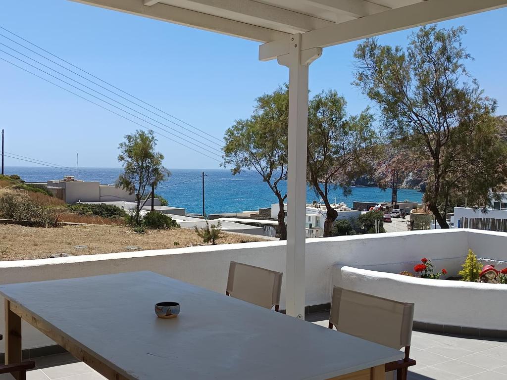 a table and chairs on a patio with a view of the ocean at Summer House Paliochori in Paliochori