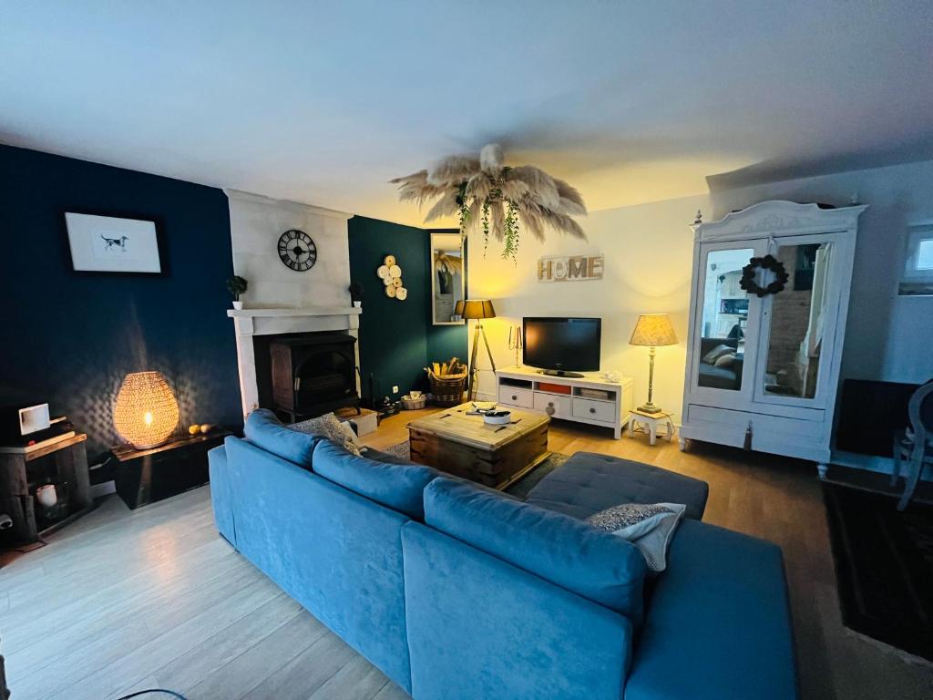 瓦洛涅的住宿－Le 33 Maison de charme coeur Cotentin，客厅配有蓝色的沙发和桌子