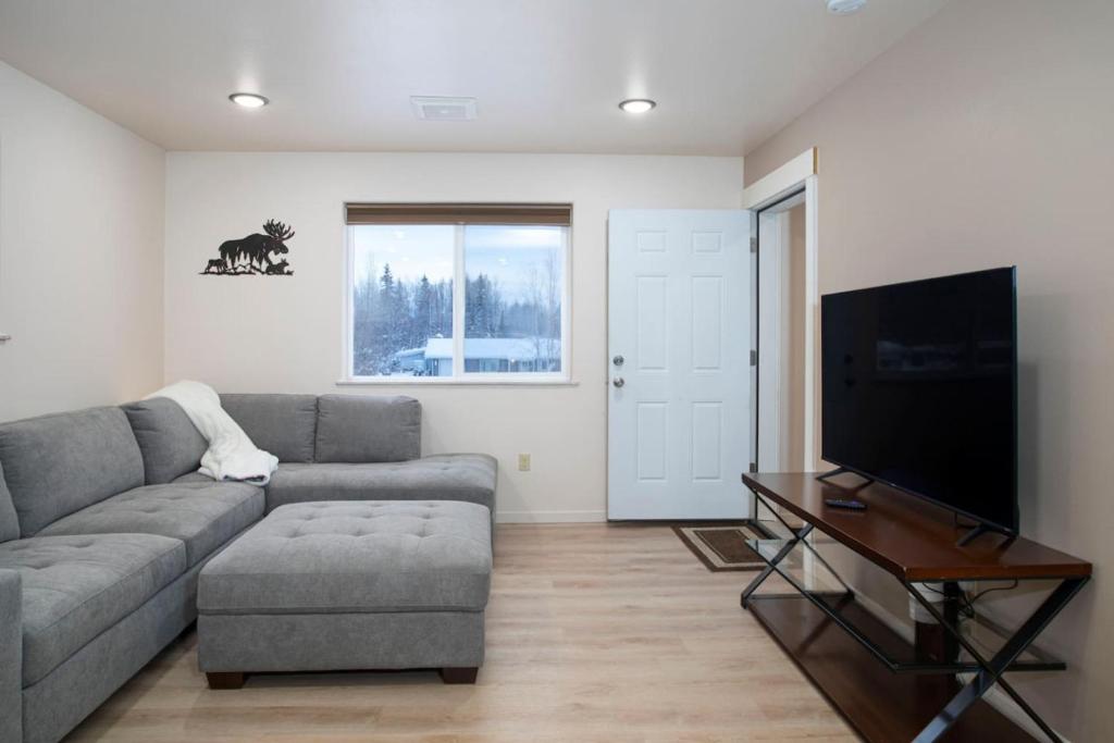 a living room with a couch and a flat screen tv at Northern Lights Getaway Minutes to Ft Wainwright in North Pole