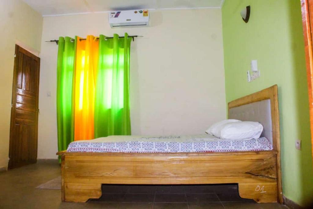 a bed in a room with a rainbow curtain at Résidence ABZ Azally in Abomey