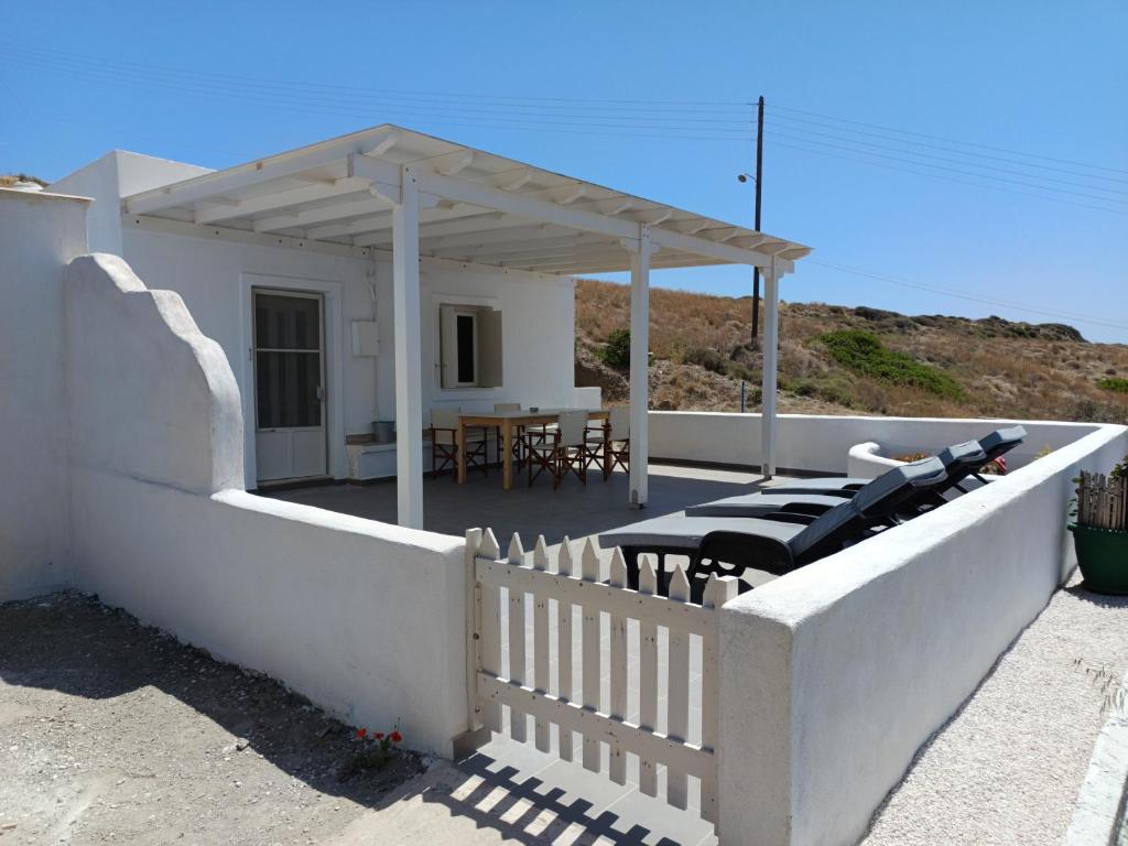a white house with a table and chairs on a patio at Summer House Paliochori in Paliochori