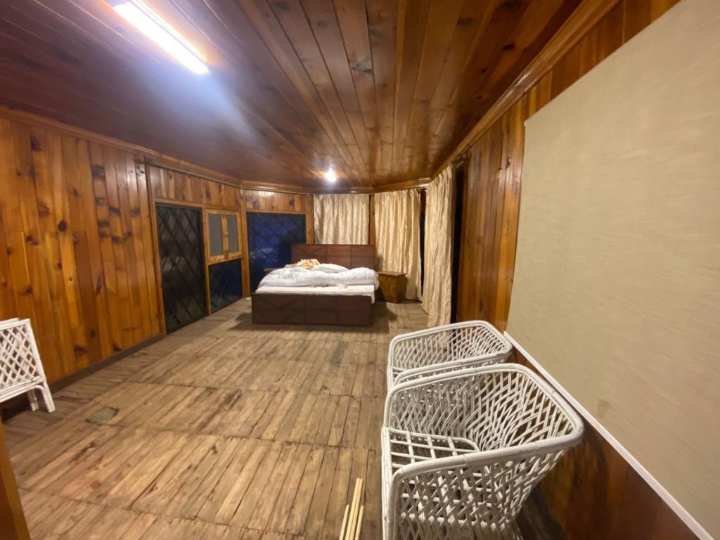 Resort66Villa2 في ابوت اباد: غرفة نوم بسرير في غرفة بجدران خشبية