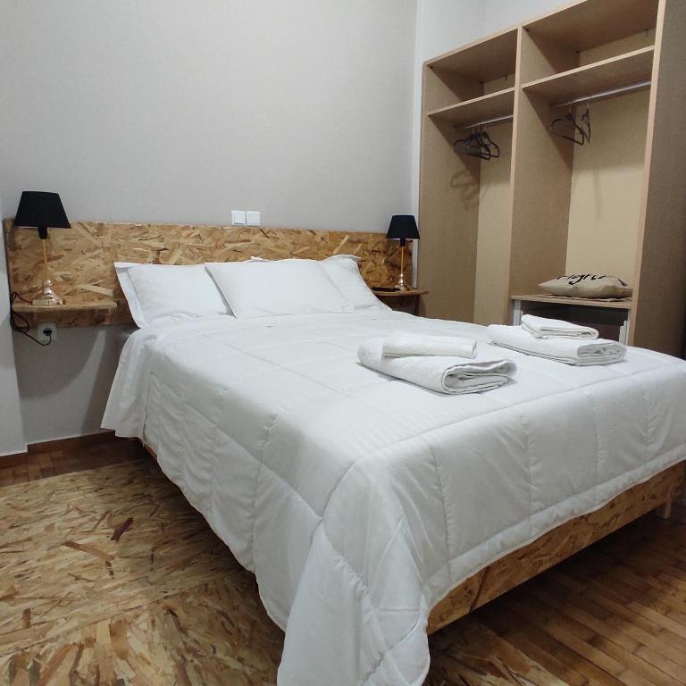 アグリニオにあるanamnesis Agrinioのベッドルーム1室(白いベッド1台、タオル2枚付)