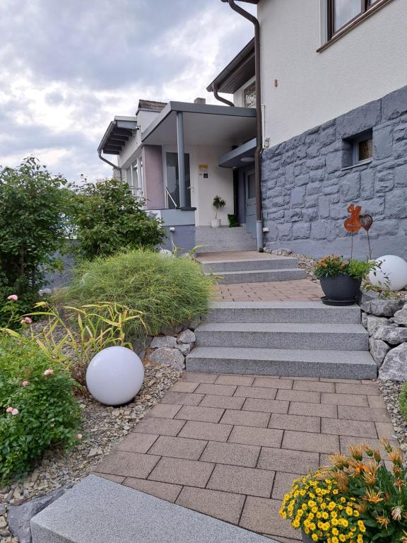 a house with a stone wall and a brick walkway at Ferienwohnung Kupfer in Niestetal