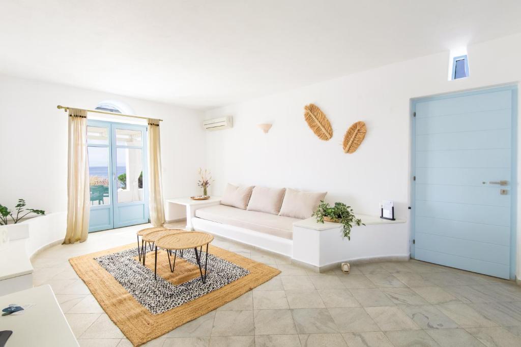 a white living room with a couch and a table at Glyfa Village in Drios