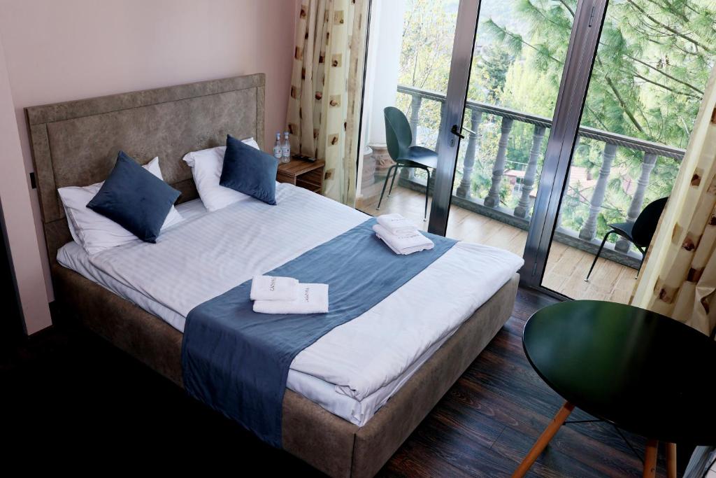 a bedroom with a bed and a large window at Casanova Inn - Boutique Hotel in Dilijan
