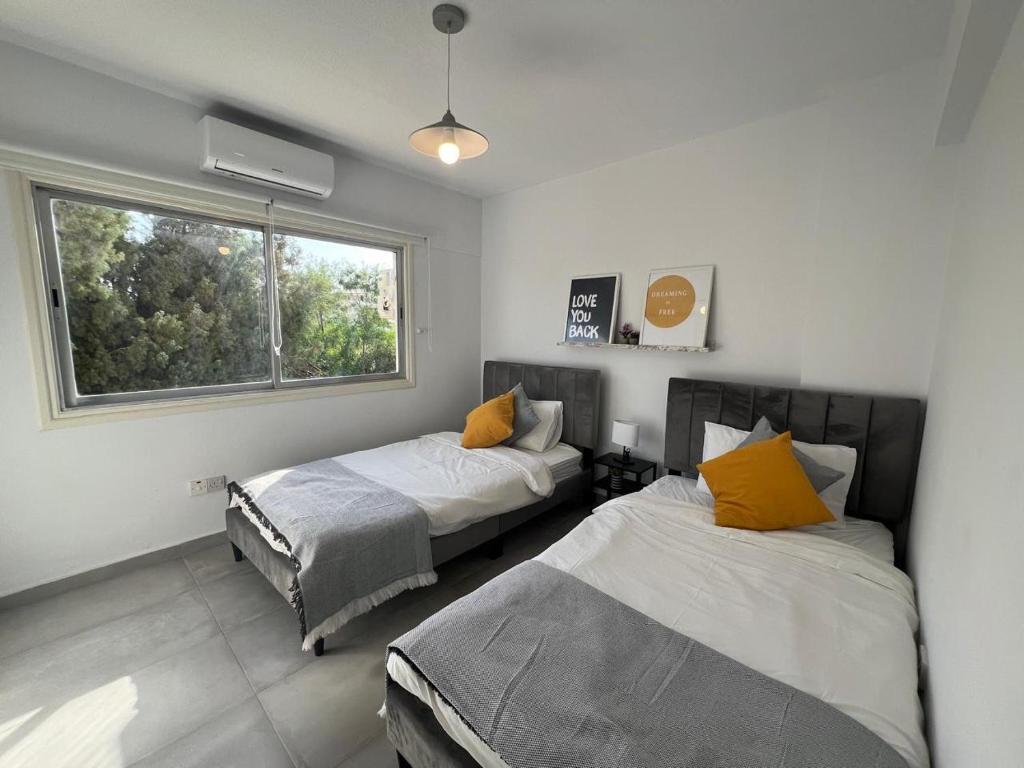 a bedroom with two beds and a window at SARA 1 in Larnaca