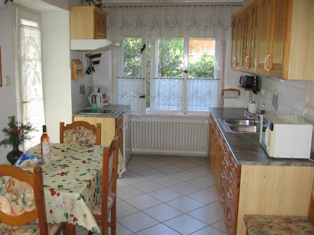 een keuken met een tafel en een wastafel en een tafel en stoelen bij Családi Vendégház in Eger