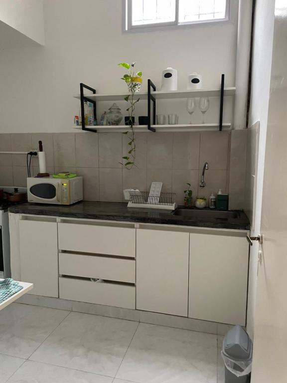 a kitchen with white cabinets and a sink at Dpto PAZ 1 in Resistencia