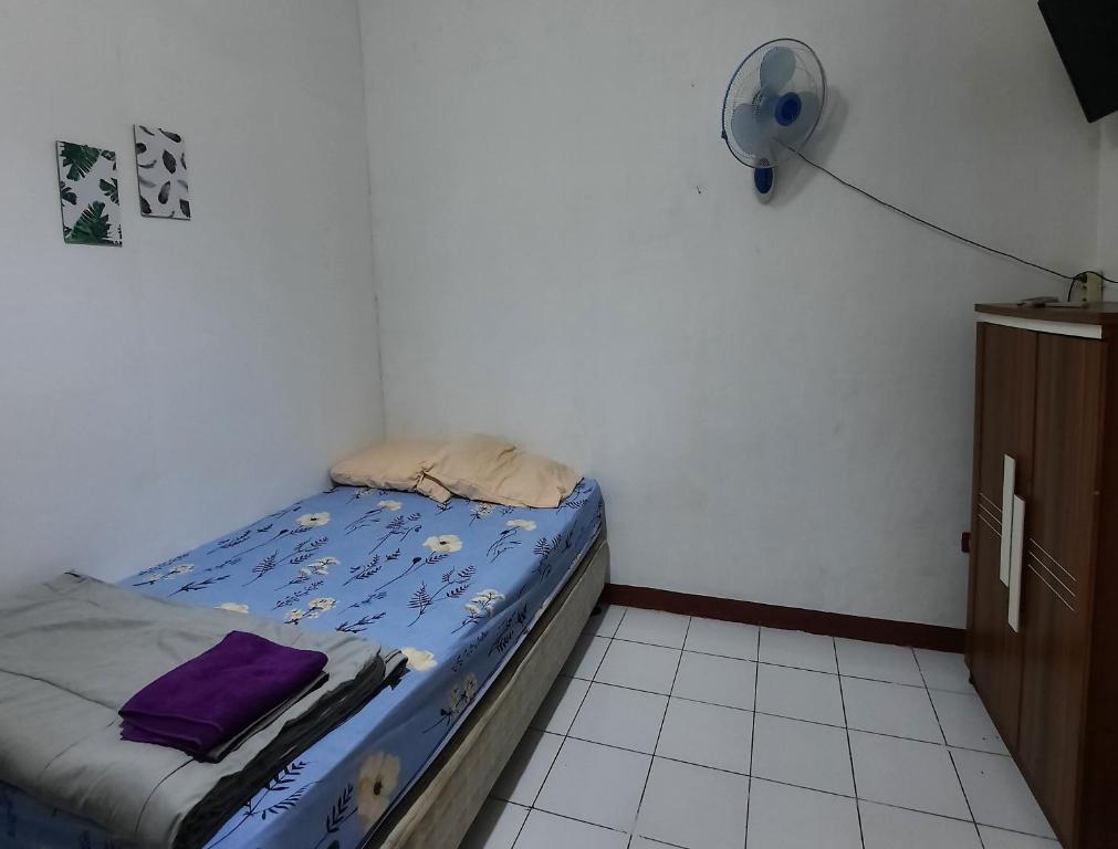 - une petite chambre avec un lit et un ventilateur dans l'établissement WISMA ACIDALIA SYARIAH, à Bandung