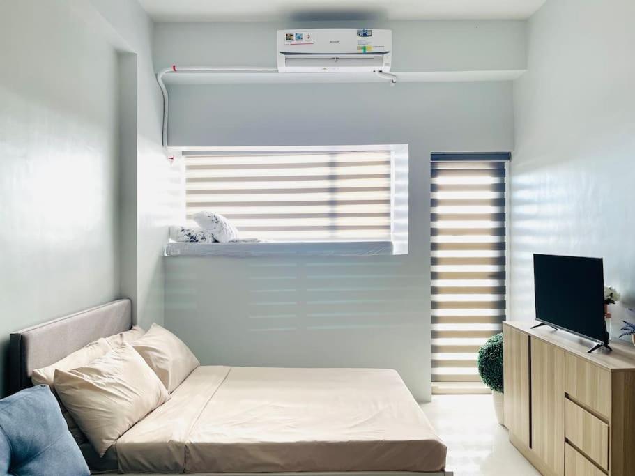 a living room with a bed and a television at WV 5 Peaceful Abode in Iloilo City
