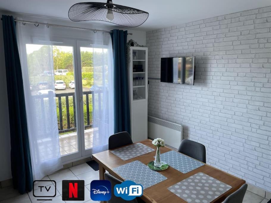 une salle à manger avec une table et une fenêtre dans l'établissement Charmant duplex, bord de mer, à Merville-Franceville-Plage