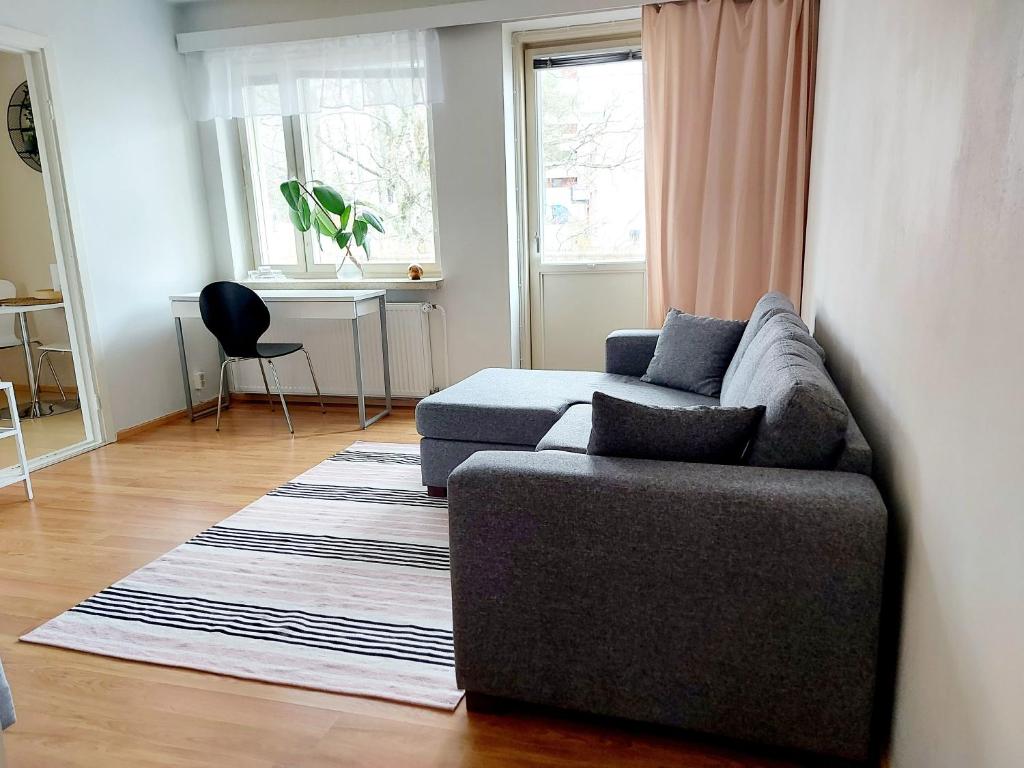 a living room with a couch and a table at Spacious studio apartment near the center of Joensuu in Joensuu