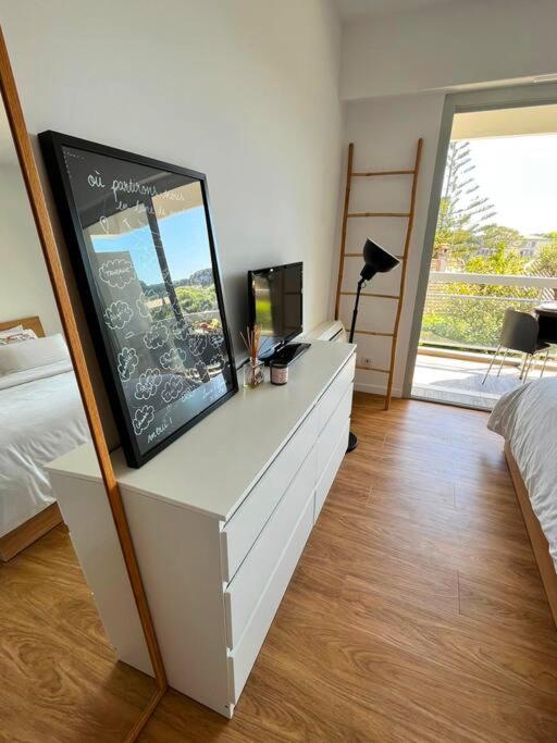 a bedroom with a dresser with a chalk board on it at Superbe Appartement, Cap d&#39;Antibes - Clim, Parking, Terrasse vue mer in Antibes