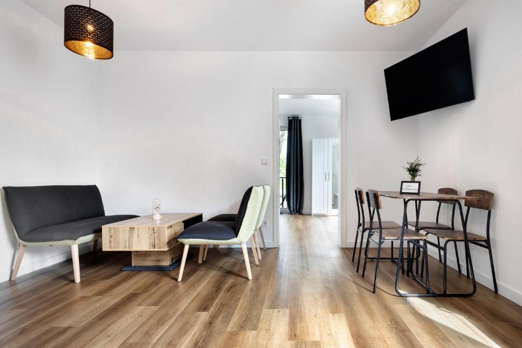a living room with a table and chairs and a tv at Eidelstedt Zentrale Lage in Hamburg