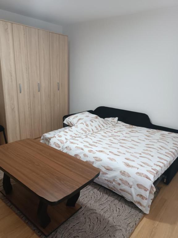 a bedroom with a bed and a wooden table at 2BDR Apt with Balcony view - Free parking 2 in Sarajevo