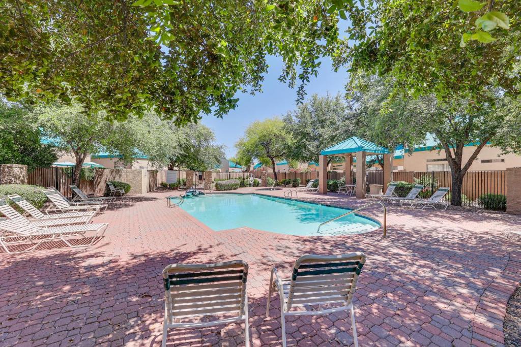 a swimming pool with two chairs and a umbrella at Mesa Townhome with Community Perks Close to Golf! in Mesa