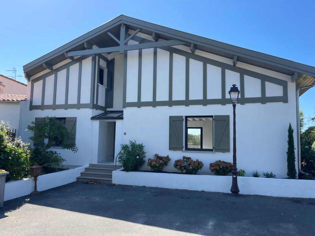 une maison blanche avec un toit en gambrel dans l'établissement Villa Péreire, à Arcachon
