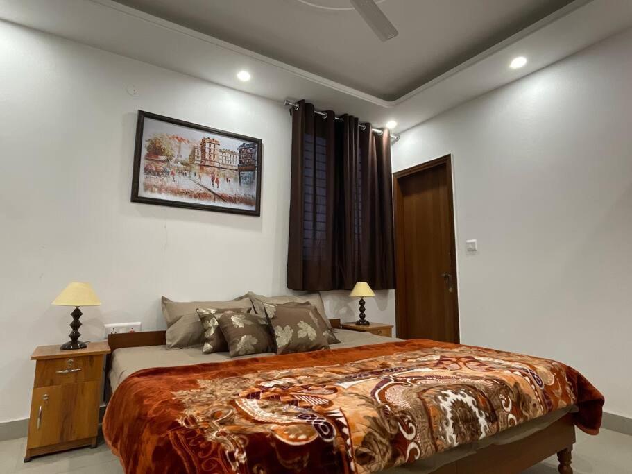 a bedroom with a large bed and two lamps at Luxurious 2BHK Flat/South Delhi/Prime Location in New Delhi