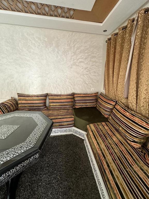 uma sala de estar com um sofá e uma cama em Kenitra em Kenitra
