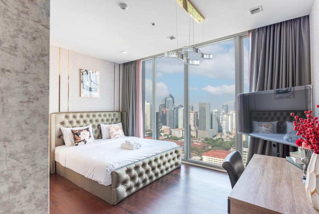 a hotel room with a bed and a large window at Skyline Suites Sukhumvit 11 in Bangkok